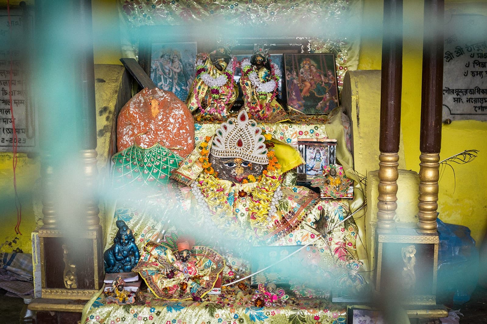 Altar con deidades de colores visto entre telas