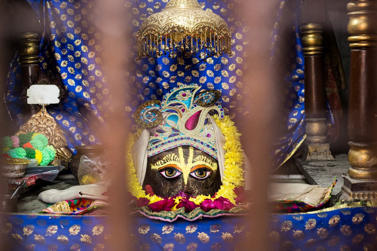 Deidad adornada en un altar con joyas y brocados